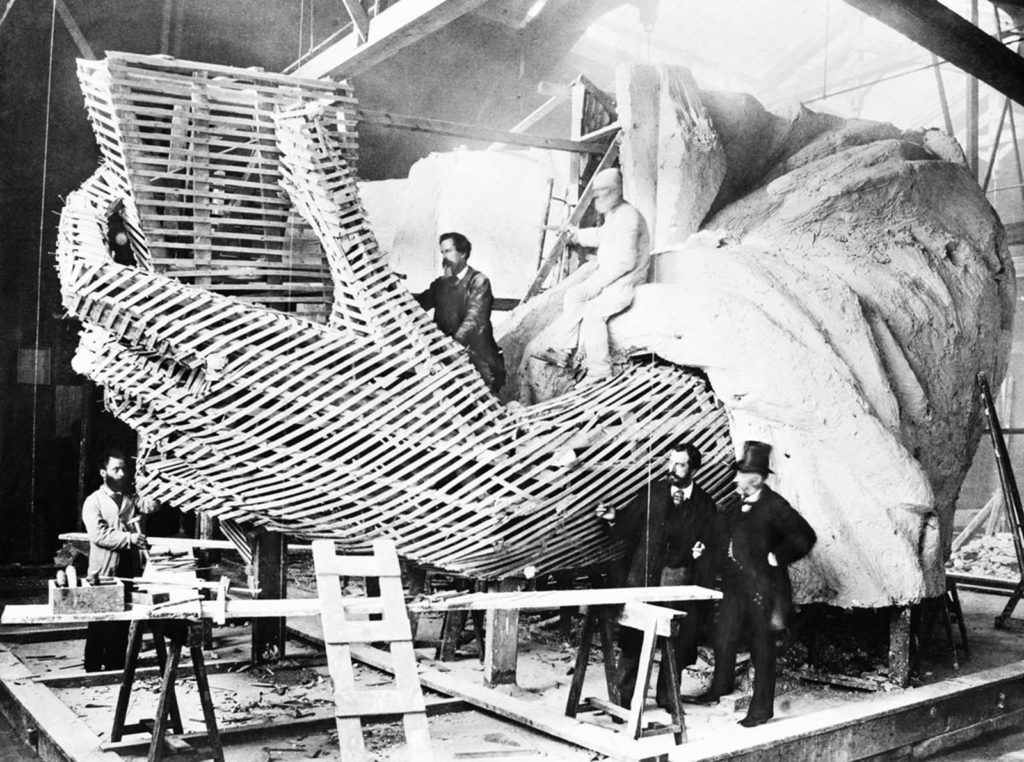 Frédéric-Auguste Bartholdi, the statue's creator, posing with a visitor at a Paris studio, 1875.