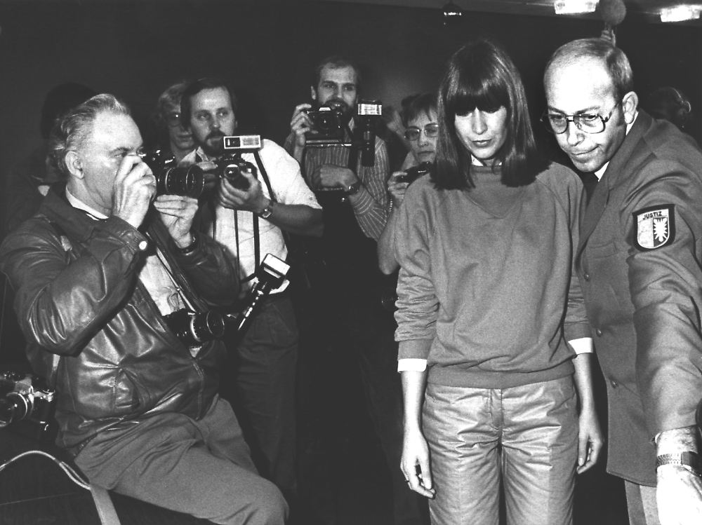 Marianna being escorted away from the press.