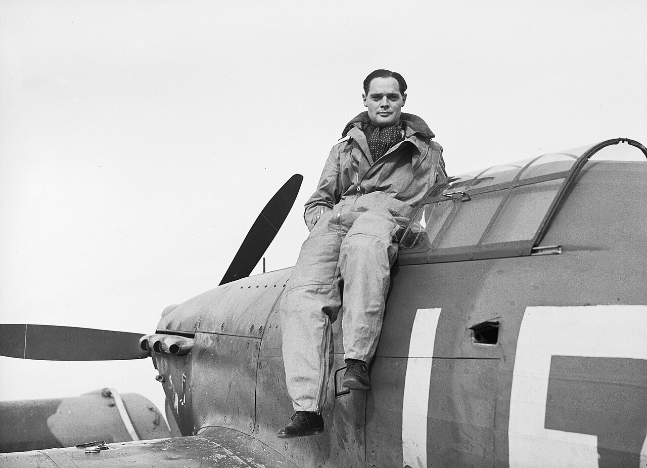 A squadron leader sitting on the cockpit edge of a Hurricane fighter