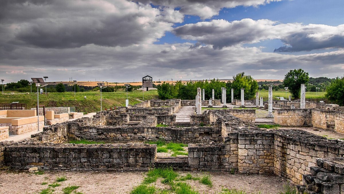 The excavated stone foundations and standing columns of the Roman town of Abritus under a cloudy sky near Razgrad, Bulgaria