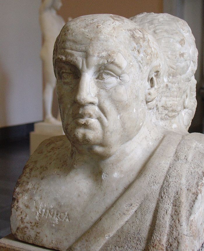 Marble portrait bust of an older balding man with a heavy face, the name SENECA carved on the chest