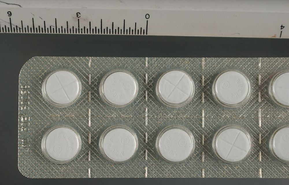 A blister pack of white Rohypnol tablets stamped Roche, photographed beside a ruler