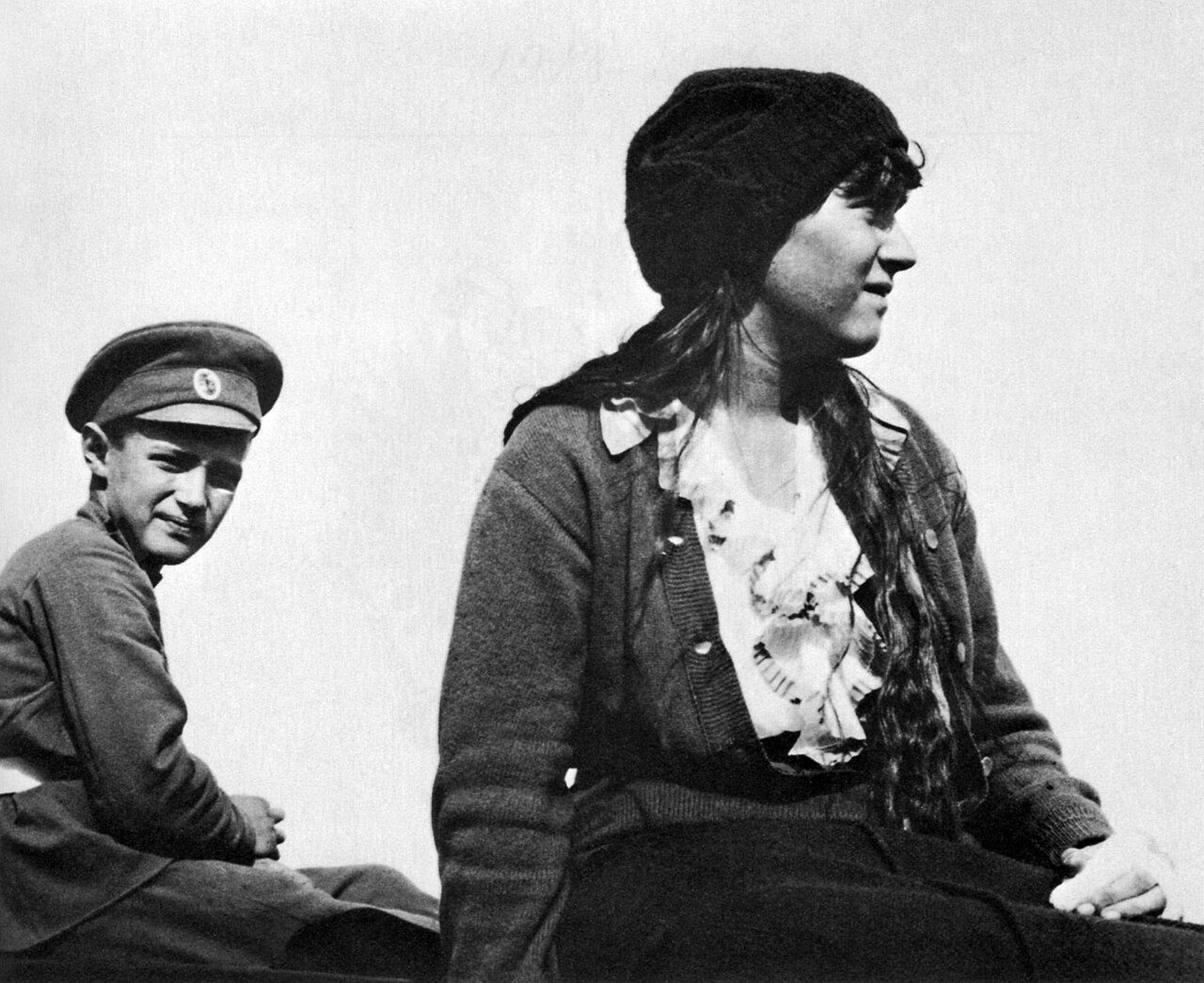 A boy in a cap and a young woman seated together on a boat
