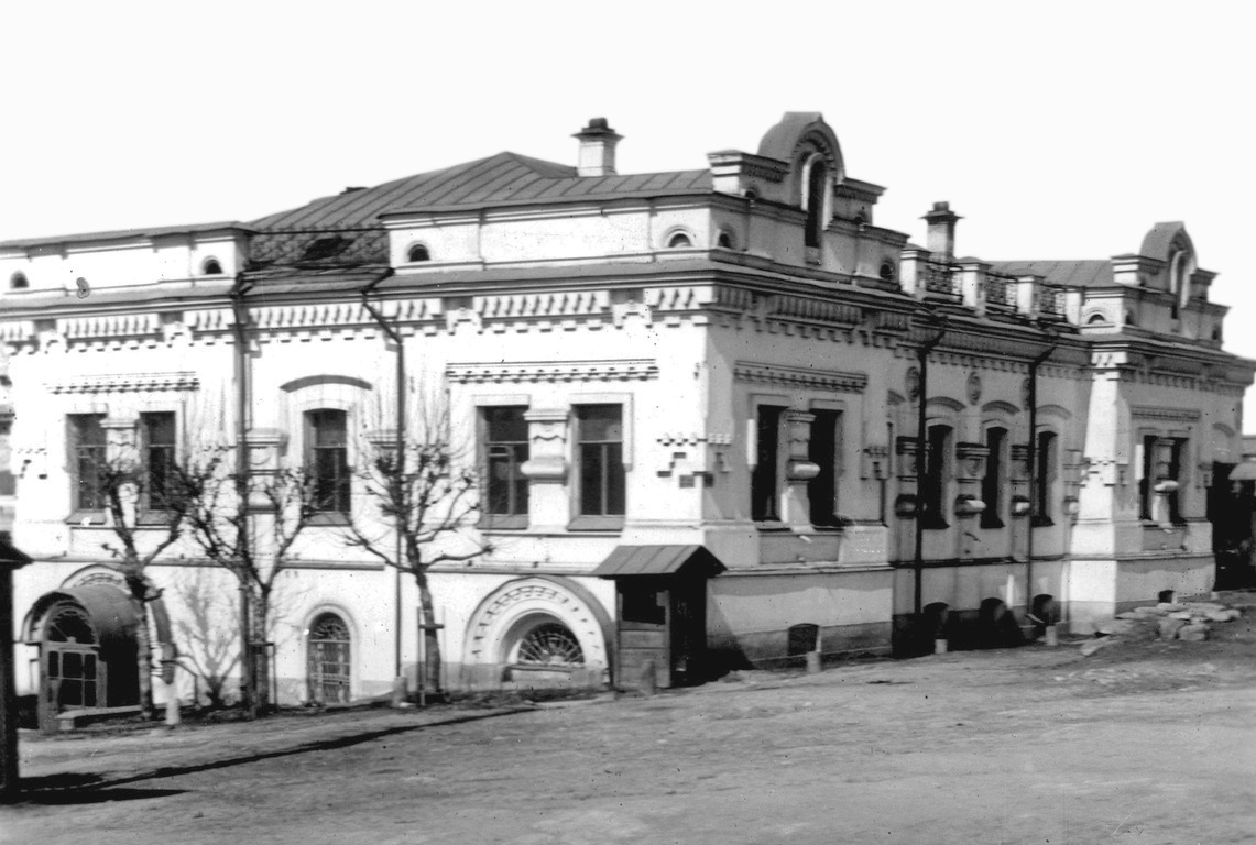 A white two-storey merchant's house on a city street corner