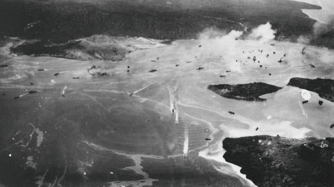 Japanese warships maneuvering in a harbor as an air attack begins