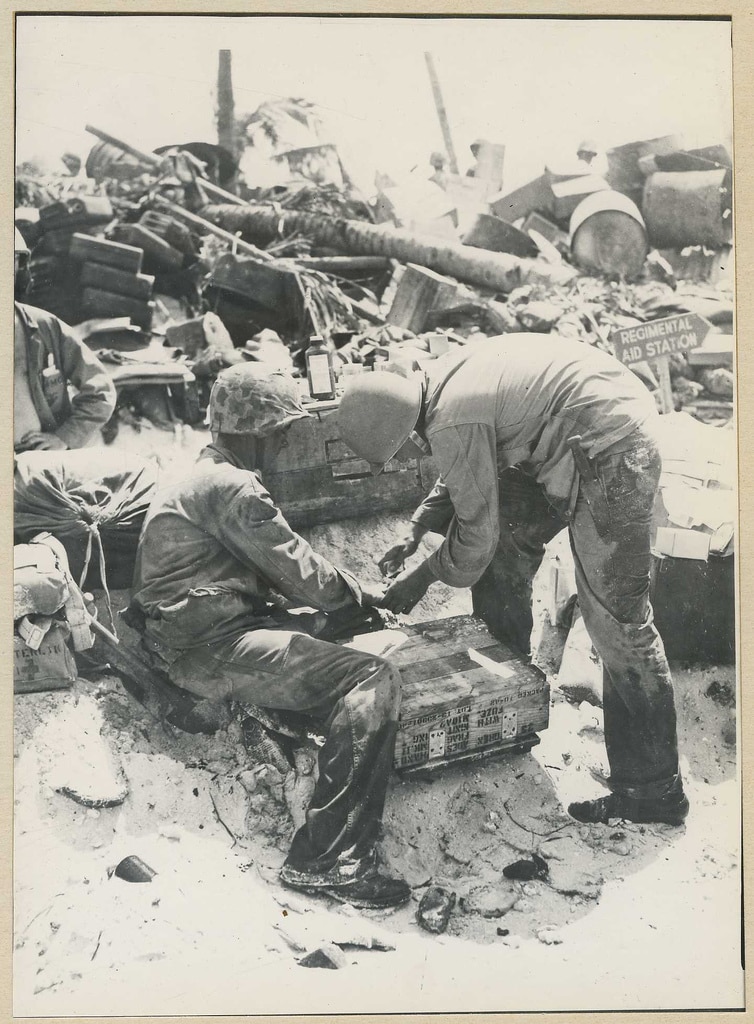 Two Marines being treated at a sandbagged regimental aid station