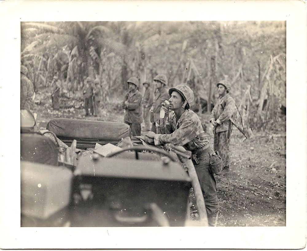 A Marine using a jeep-mounted loudspeaker system in the field
