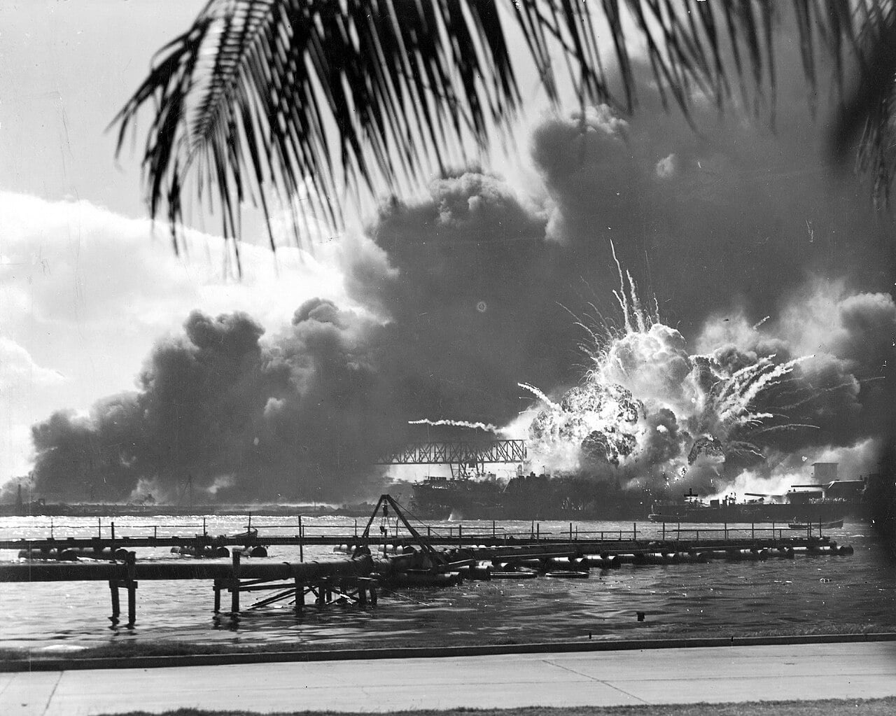 The destroyer USS Shaw's forward magazine detonating in a fireball above a floating drydock