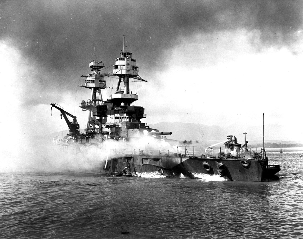 The battleship USS Nevada beached and burning near the harbor entrance