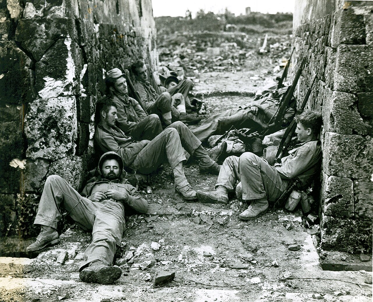 Exhausted Marines of a mortar crew asleep on the ground