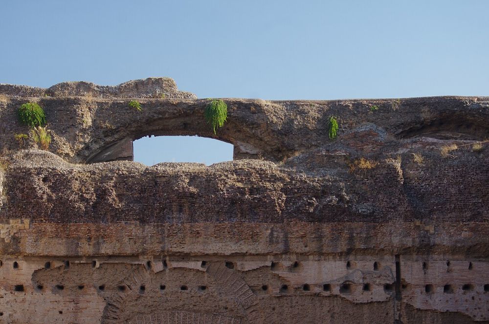 The upper wall of the Baths of Caracalla in Rome, showing a brick facing over a rough concrete core with a collapsed vault opening