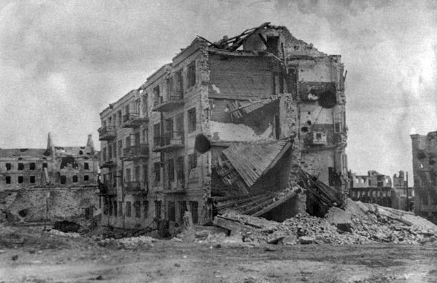 A four-storey apartment block with one corner collapsed and every wall pitted by fire